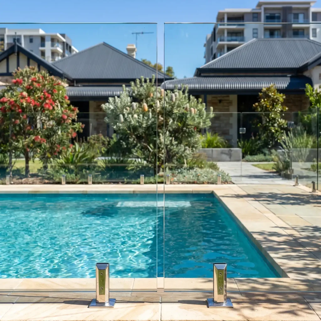 Repaired frameless glass pool fence panel and stainless steel spigots beside a pool in Northbridge