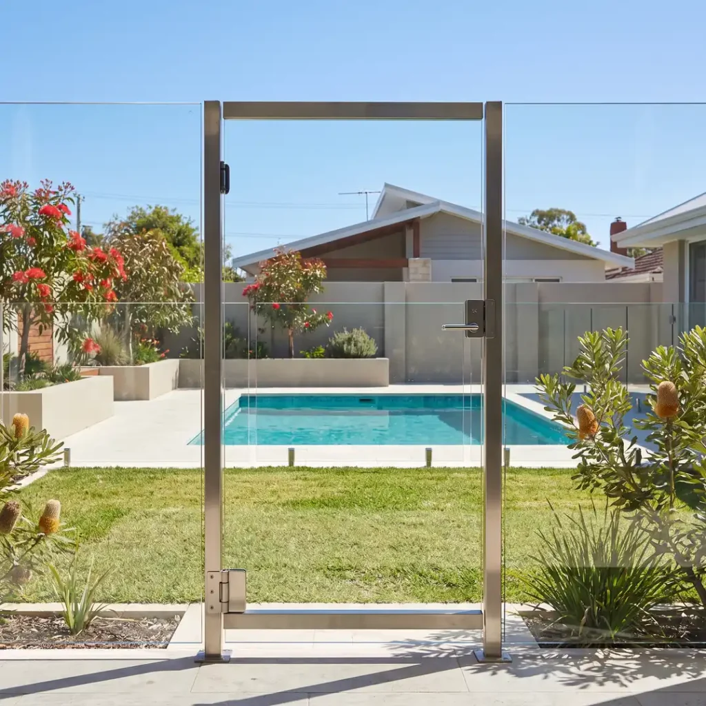 Frameless glass pool gate with stainless steel latch beside a backyard pool in Northbridge WA