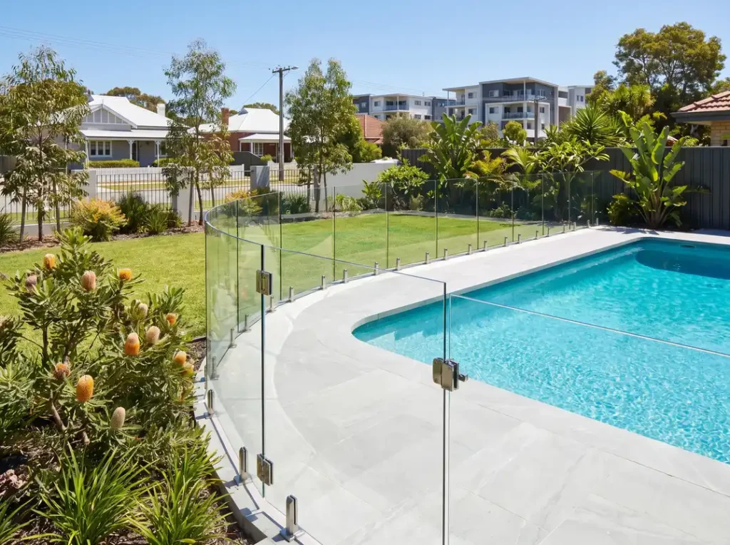 Frameless glass pool fencing with self-closing gate around a backyard pool in Northbridge WA