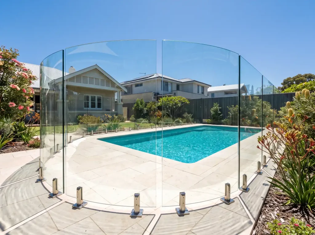 Frameless glass pool fence around a backyard pool built for Perth conditions in Northbridge WA