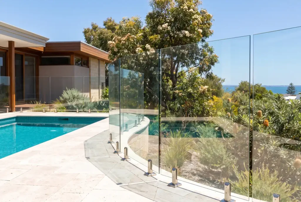 Frameless glass pool fencing framing a turquoise backyard pool in Northbridge, WA