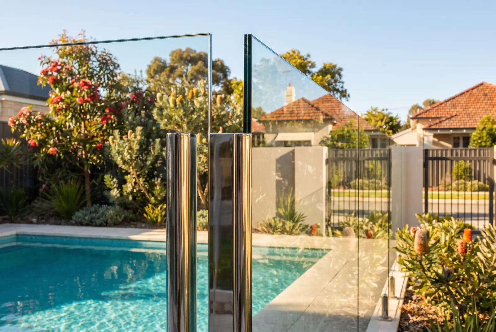 Frameless glass pool fence installation detail with polished spigots in Northbridge
